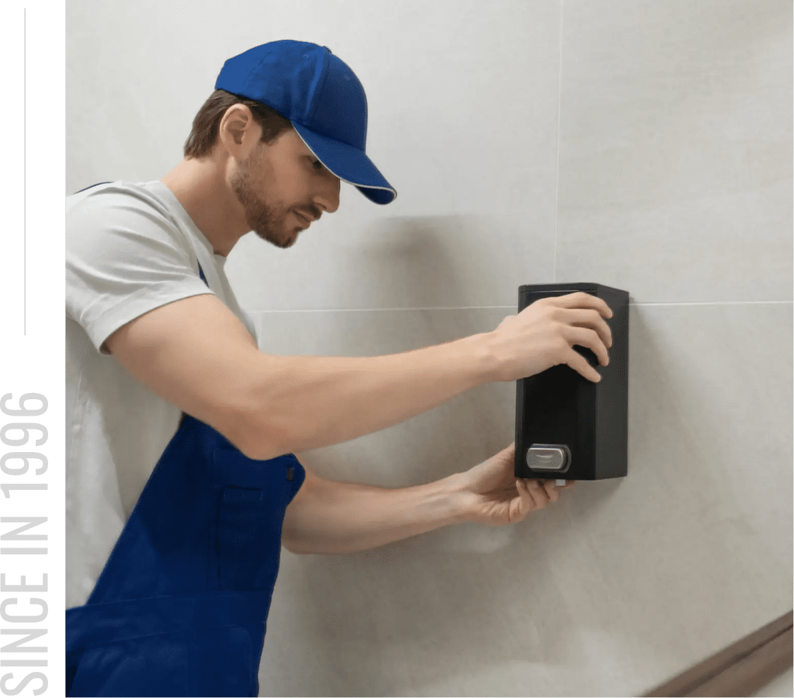 Worker installing wall-mounted dispenser