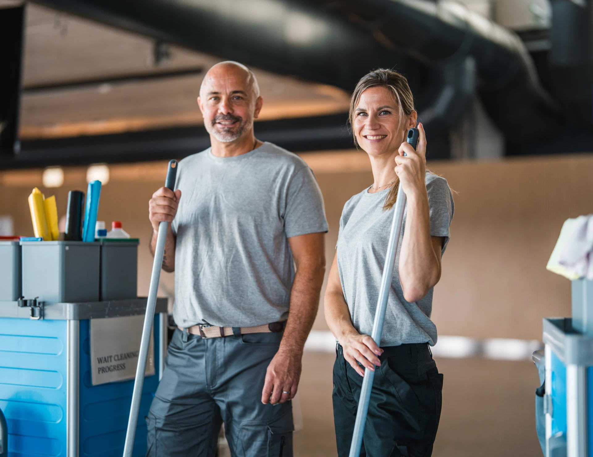 Smiling janitors in grey shirts